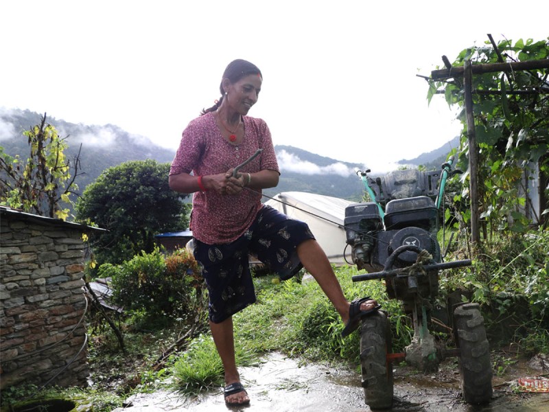 हाते ट्रयाक्टर चलाउँदै महिला किसान